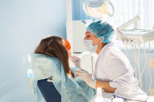 woman getting treatment from dentist